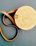 Stylish round rush and reed bag with a leather strap, eco-friendly and elegant design.
