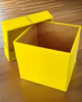 Open yellow gift box placed on the floor, showcasing its spacious interior