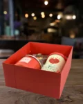 Red self-care gift box with candle, fragrance, and heart-themed mug – ideal for gifting someone special