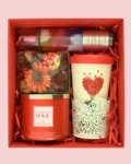 Red self-care gift box with candle, fragrance, and heart-themed mug – ideal for gifting someone special